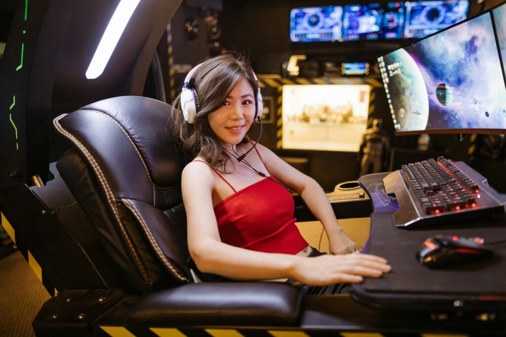 pexels-photo-7915266-7915266 A woman seated at an advanced gaming setup featuring a scorpion gaming chair, multiple monitors, and gaming peripherals.